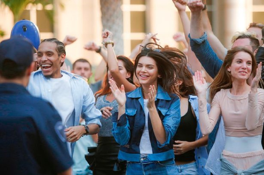 The crowd cheering after Kendall shared the Pepsi with the cop.